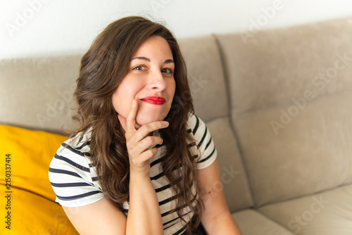 Young woman thinking contemplating planning future on sofa