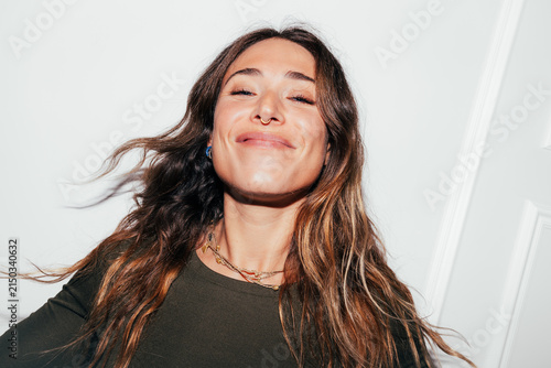 Smiling young woman portrait with long hair and septum ring