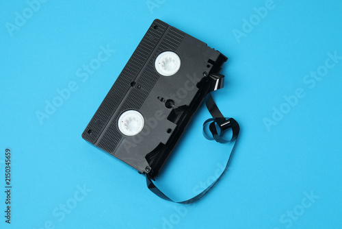 A video cassette against a colored background. An old analog VHS cassette, close-up. Retro and vintage.
