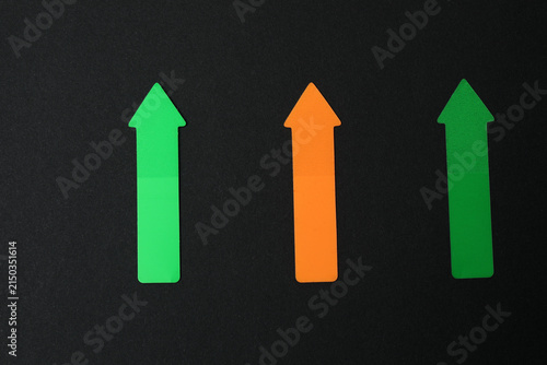 Paper arrow on color background, top view