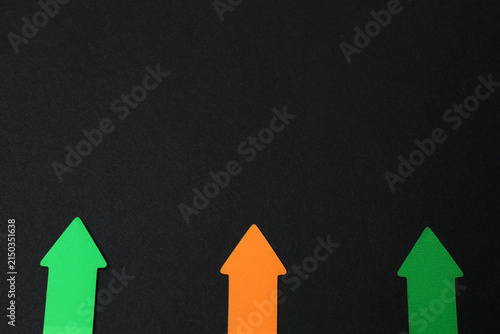 Paper arrow on color background, top view
