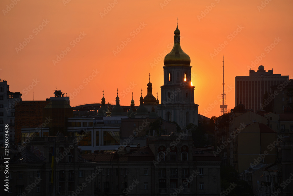 Fototapeta premium Kyiv, Ukraine - August 6, 2026: Summer sunset against the backdrop of St Sophia's Cathedral and the Kyiv TV Tower. The daytime temperature reached 39 degrees Celsius.