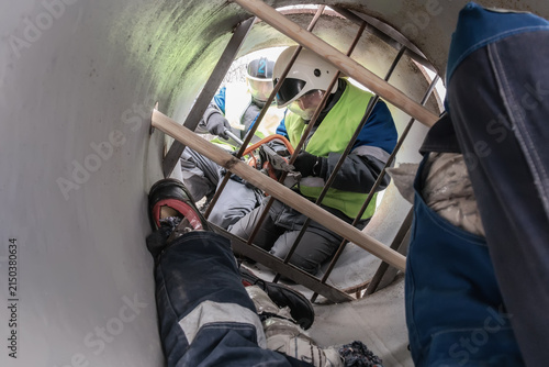 Cuadro en lienzo Safety professionals conduct a rescue operation inside a confined space, ensuring proper techniques and equipment are used