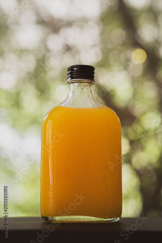 Canvas Print A fresh orange juice glass bottle with a black cap
