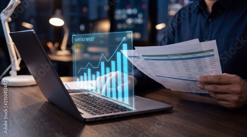 Man analyzing financial data and graphs on a laptop with holographic projection