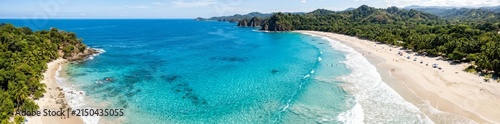 Panoramic Aerial View of Tropical Turquoise Beach and Lush Green Coastline