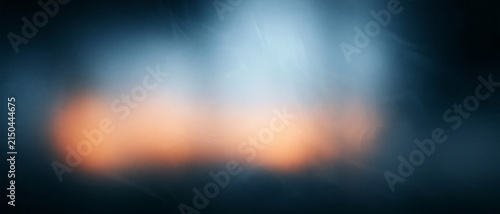 Abstract dark frosted glass blur with warm orange light bokeh ambient texture background banner