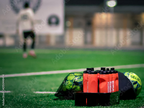 Sports Water Bottles and footballs on Artificial Turf Field