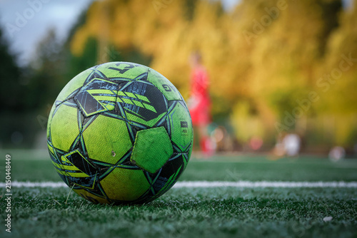Soccer Ball on Artificial Turf with Players in Background