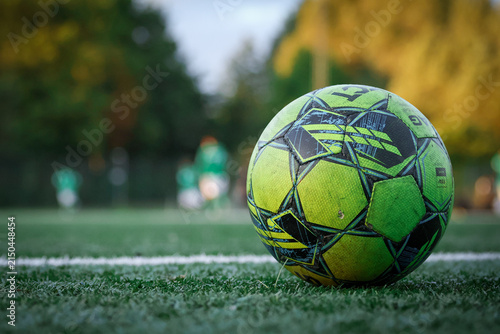 Soccer Ball on Artificial Turf with Players in Background