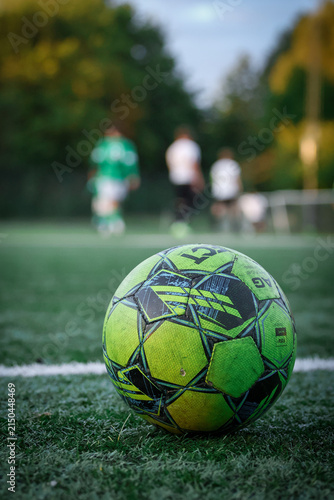 Soccer Ball on Artificial Turf with Players in Background