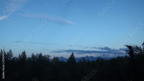 Timelapse transition to night with moonrise and clouds over Alaska.
