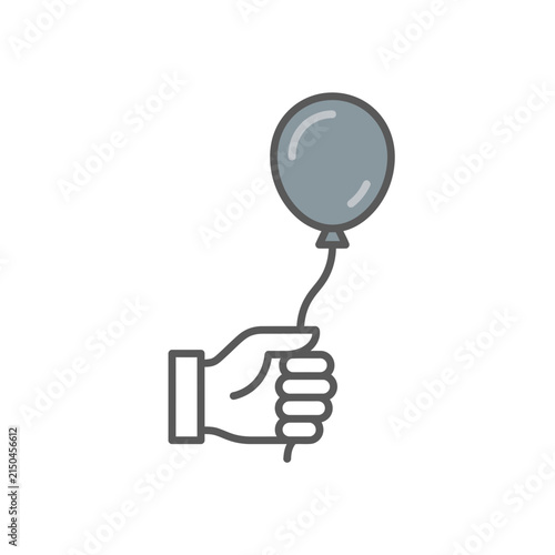 Hand holding balloon string against plain background