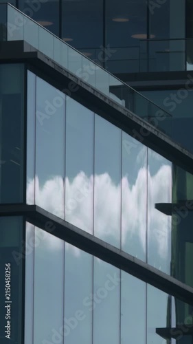 Blue sky and clouds reflection on city office building windows