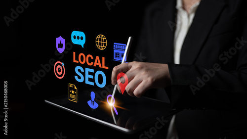 Fotografie A professional woman interacts with her tablet to showcase local SEO elements, featuring vibrant graphics on a dark backdrop, representing modern digital marketing
