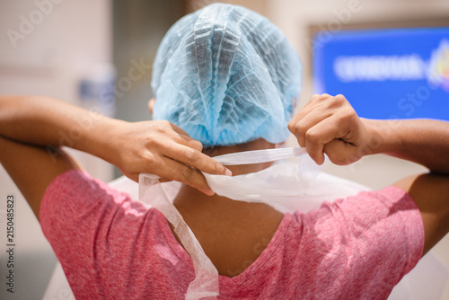 Tying Surgical Apron Before Medical Procedure, Back View