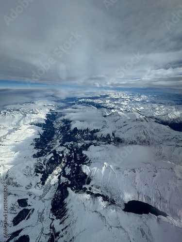 Konstfotografi snow-covered mountains hover majestically above the high-altitude landscape, offering a serene and breathtaking aerial perspective on nature's grandeur and adventure