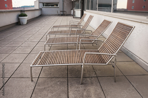 Modern wooden sun loungers on a spacious outdoor hotel terrace