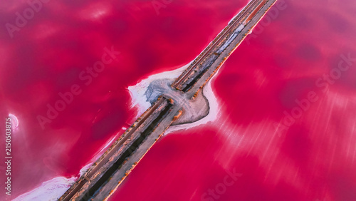 Quadro su tela Aerial drone view of pink lakes salt marshes, salt mining medieval town of Aigues-Morte, Camargue, France