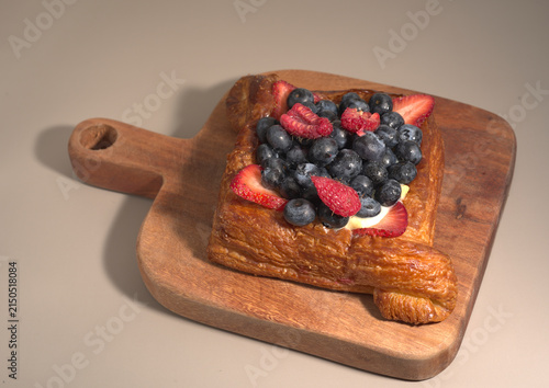 Quadro su tela Mixed Berry Danish Pastry on Wooden Board with Neutral Background