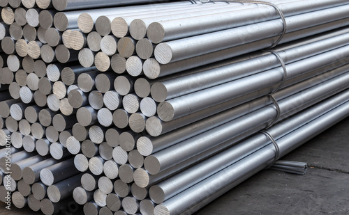 Solid aluminum round bars piled up inside industrial factory workshop