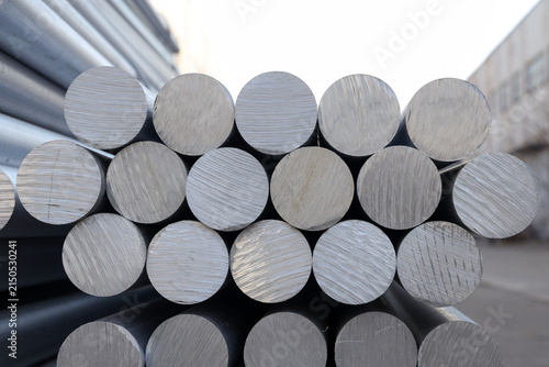 Solid aluminum round bars piled up inside industrial factory workshop