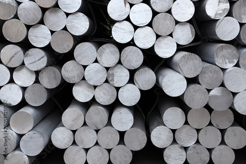 Solid aluminum round bars piled up inside industrial factory workshop