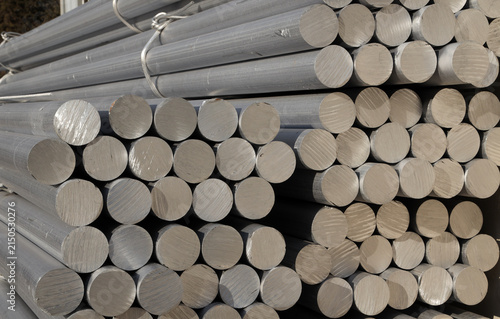 Solid aluminum round bars piled up inside industrial factory workshop