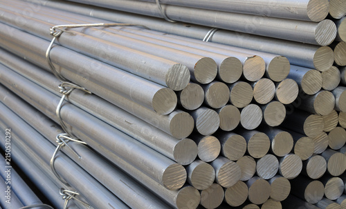 Solid aluminum round bars piled up inside industrial factory workshop