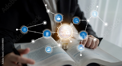 Fotografie A business professional reviews data trends in a modern workspace, highlighting innovation and technology with a light bulb concept over an open book