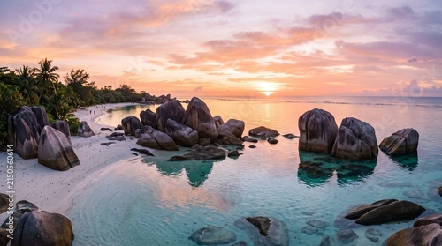 Tropical beach at sunset with massive granite boulders and clear turquoise water