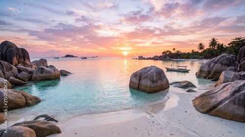 Tropical beach at sunset with large rocks and calm ocean water, tropical