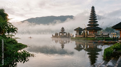 Traditional balinese temple on beratan lake with foggy mountain background