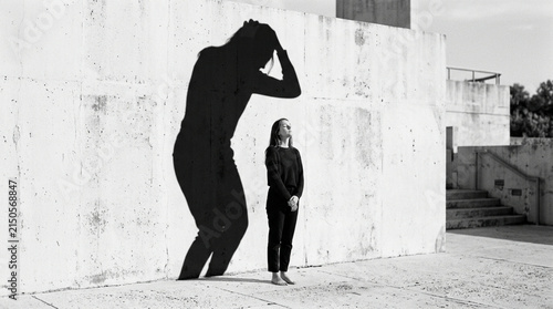 Woman's Shadow Cast as Giant Monster on Wall, Mental Health Concept