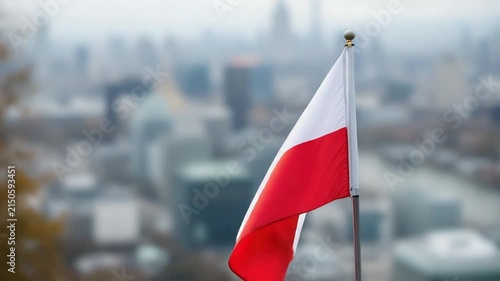 Polish National Flag Waving in Front of Blurred City Skyline
