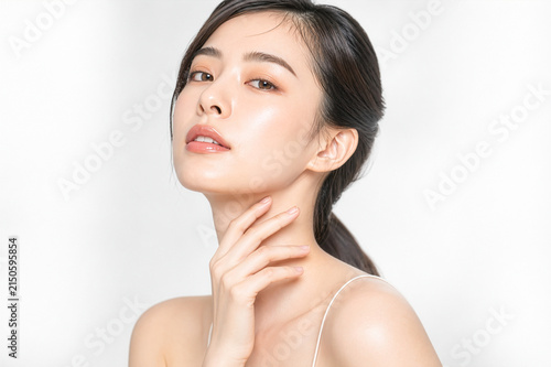 首元に手を添えている透明感のある艶肌とすっきりしたフェイスラインが印象的な日本人女性の美容とフェイスケアのイメージ