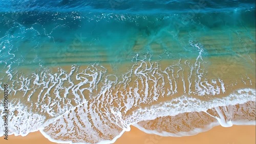 Aerial View of Clear Turquoise Ocean Waves Rolling Over a Golden Sandy Beach Creating Beautiful Natural Foam Patterns and Coastal Textures.