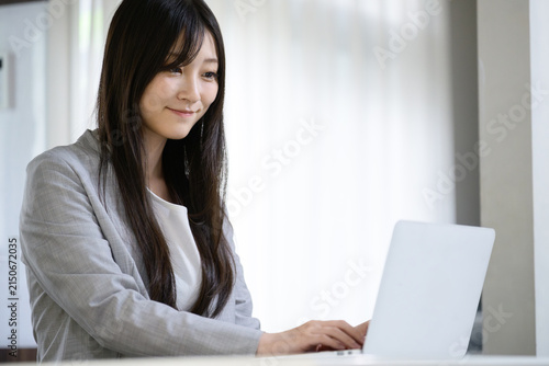 Naklejka リビングでノートパソコンを操作する日本人女性