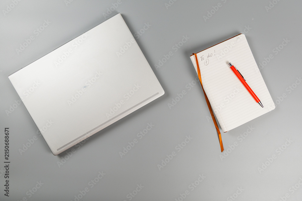 Fototapeta premium Planning work tasks with a laptop and a notebook on a desk