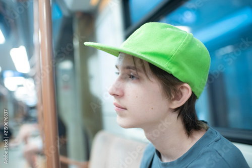 Thoughtful teenage boy passenger inside subway train wagon