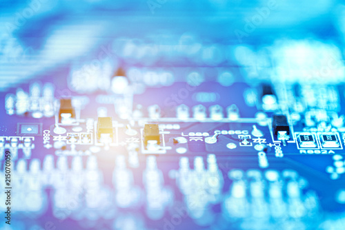 Abstract close-up of an electronic circuit board with blurred components and glowing light effects. Digital technology and innovation concept.