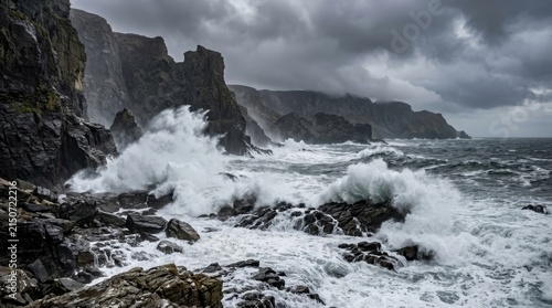 Dramatic coastal cliffs battered by powerful ocean waves under a stormy sky