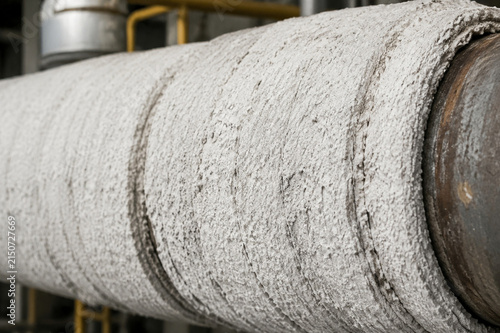 Thick white insulation lagging wrapped around an industrial steam pipe.