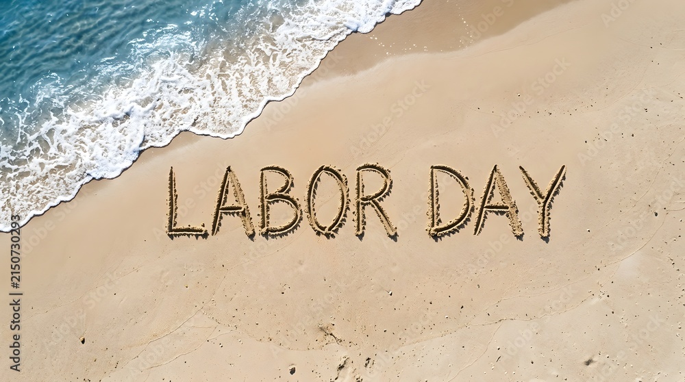 Fototapeta premium The words labor day written in the sand on a tropical beach with ocean waves in the background