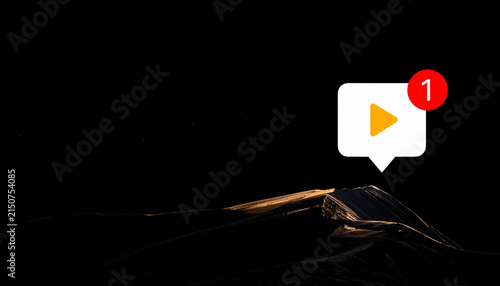 Dramatic landscape with a video notification icon, a play button, and a notification badge with the number one