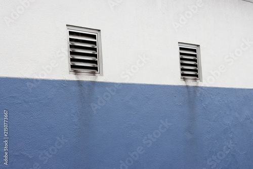 White and blue concrete wall with air vent grille perspective background
