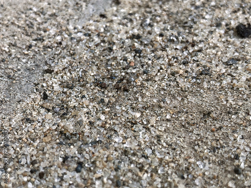 Photography Low angle macro of coarse mineral sand and sparkling grains on a rough surface, suited for aggregate, construction material, geology, texture, filtration, and industrial concepts