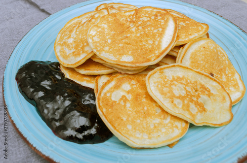 Homemade Mini Pancakes with Blueberry Jam on a Blue Ceramic Plate