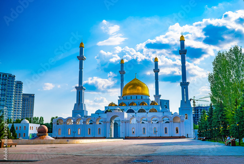 Fotografía Abu Nasr al-Farabi mosque with golden dome and minaret against blue sky in Astan