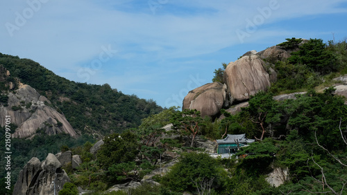 Peaceful hermitage on a granite cliff at Inwangsan mountain surrounded by green pine trees